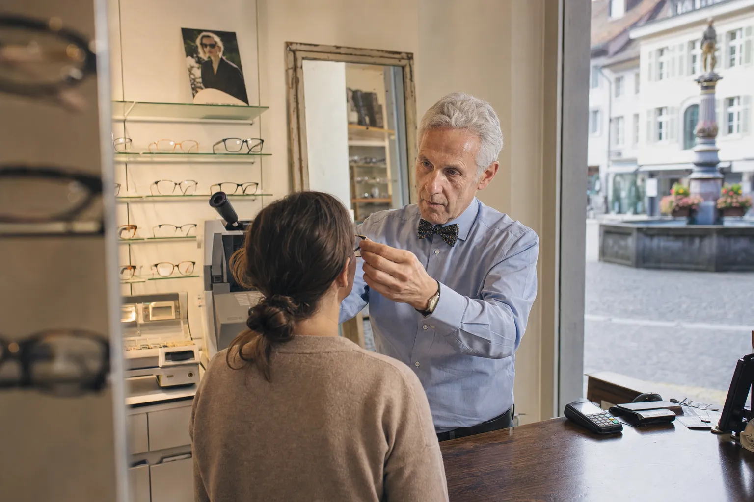 Opticien ajustant des lunettes sur une cliente, Genève