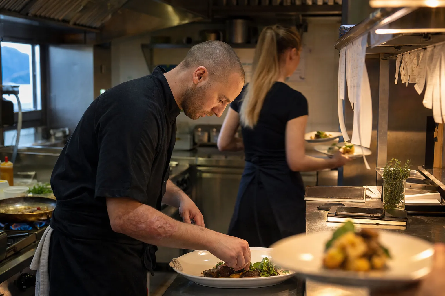 Chef au passe d'une petite cuisine de restaurant, Lausanne
